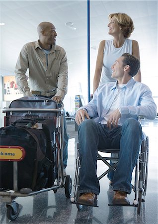 Travelers in airport, one in wheelchair Stock Photo - Premium Royalty-Free, Code: 695-05763315
