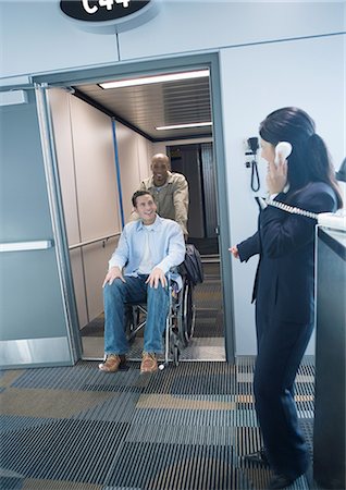 Voyageur en fauteuil roulant qui arrivent à la porte de l'aéroport Photographie de stock - Premium Libres de Droits, Code: 695-05763317