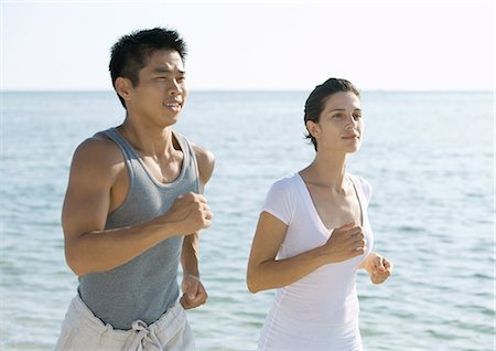 fitness asian couple - Couple running next to ocean Stock Photo - Premium Royalty-Free, Code: 695-05763471