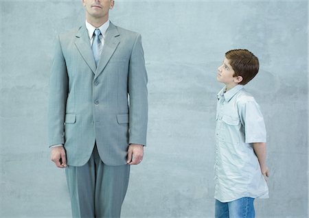 Boy looking up at businessman Stock Photo - Premium Royalty-Free, Code: 695-05763501