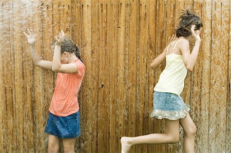 Girls getting wet in sprinkler Stock Photo - Premium Royalty-Free, Code: 695-05763542