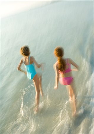 Two girls running in surf Stock Photo - Premium Royalty-Free, Code: 695-05763595