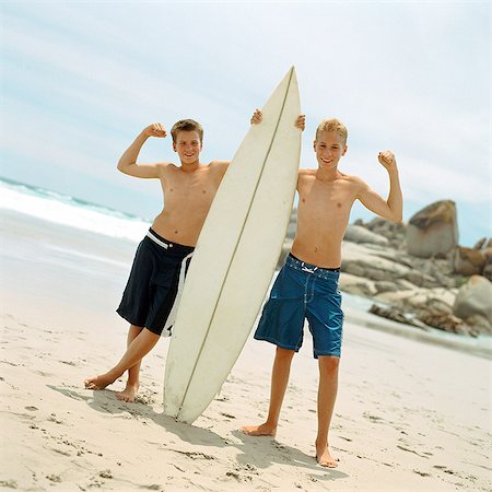 Two boys on beach holding surfboard Stock Photo - Premium Royalty-Free, Code: 695-05774078