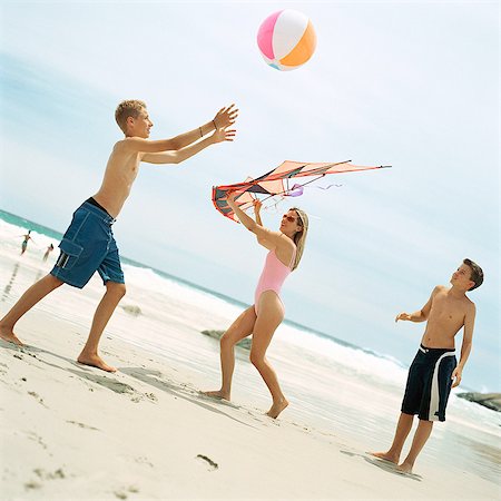 Two boys playing with beach ball, woman holding kite Stock Photo - Premium Royalty-Free, Code: 695-05774079