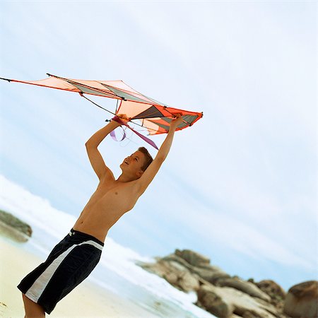 sky in kite alone pic - Teenage boy holding kite at the beach Foto de stock - Sin royalties Premium, Código: 695-05774081