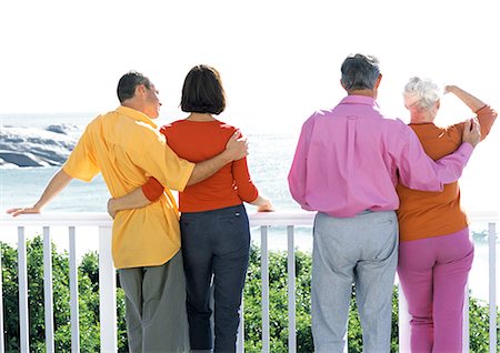 pictures of a family relaxing on the patio in summer - Two couples looking out to sea, rear view Stock Photo - Premium Royalty-Free, Code: 695-05774354