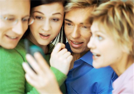 face to internet technology - Group of four people using cell phone, blurred, close up Stock Photo - Premium Royalty-Free, Code: 695-05774682