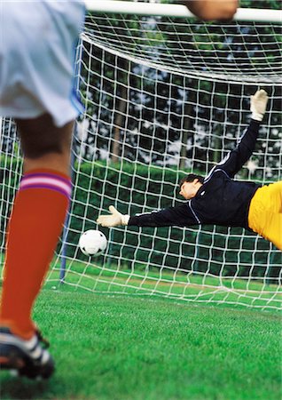 penalty - Goal keeper diving for ball during a match. Stock Photo - Premium Royalty-Free, Code: 695-05775838