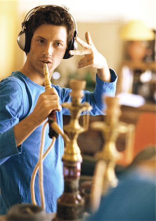 Man wearing headphones, holding hookah like a microphone Stock Photo - Premium Royalty-Free, Code: 695-05776165