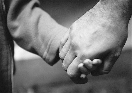 protector - Adult's hand holding child's hand, close-up, b&w Stock Photo - Premium Royalty-Free, Code: 695-05776417