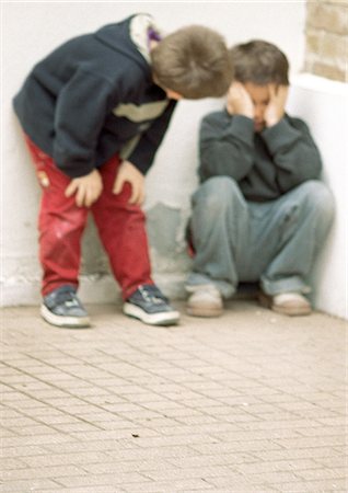 Two children in corner, one holding head Stock Photo - Premium Royalty-Free, Code: 695-05776431