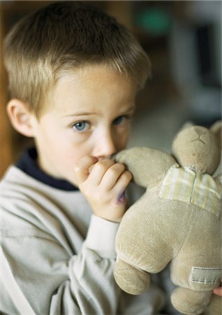 Child with thumb in mouth holding stuffed animal, portrait Stock Photo - Premium Royalty-Free, Code: 695-05776486