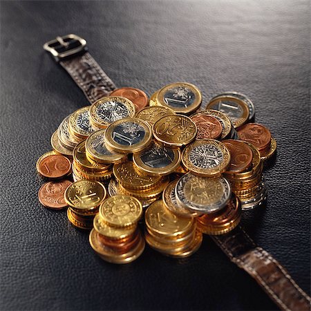 Pile of assorted euro coins on top of watch band Stock Photo - Premium Royalty-Free, Code: 695-05776619