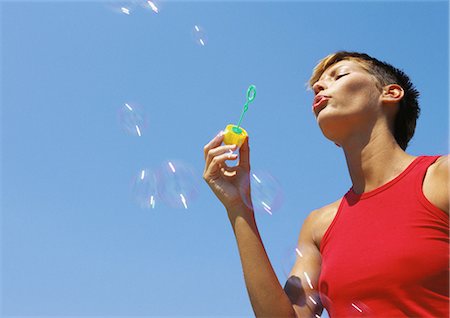 Woman blowing bubbles, low angle view Stock Photo - Premium Royalty-Free, Code: 695-05776914
