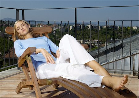 Woman lying on lounge chair outside Stock Photo - Premium Royalty-Free, Code: 695-05777040