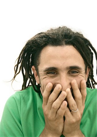 Man smiling, covering mouth with hands, portrait Stock Photo - Premium Royalty-Free, Code: 695-05777125