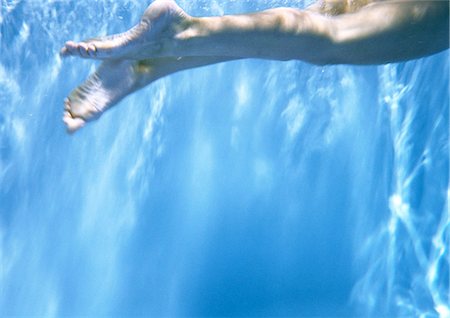 Person swimming underwater, cropped view of legs Stock Photo - Premium Royalty-Free, Code: 695-05777215