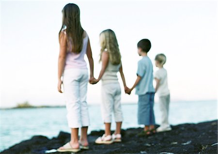 fraternization - Children standing, holding hands, looking out to sea Stock Photo - Premium Royalty-Free, Code: 695-05777238