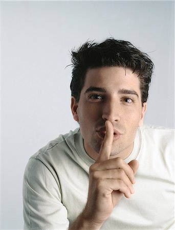 shhh - Man with finger on lips, looking at camera Stock Photo - Premium Royalty-Free, Code: 695-05777260