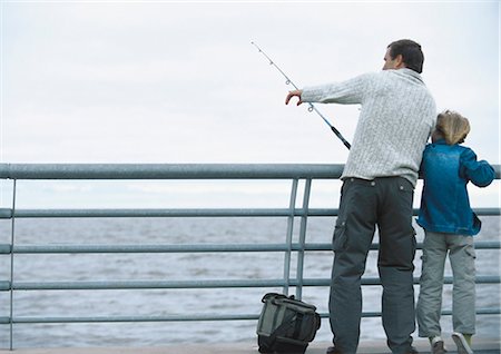 Man and son fishing on pier, man pointing, full length Stock Photo - Premium Royalty-Free, Code: 695-05777418