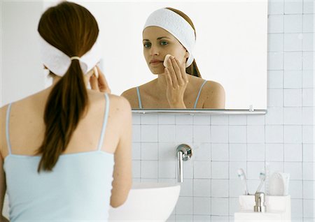 Woman washing face in front of mirror Stock Photo - Premium Royalty-Free, Code: 695-05777452