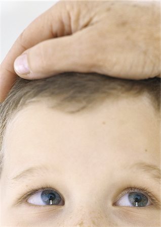 Adult's hand on child's head, close-up Stock Photo - Premium Royalty-Free, Code: 695-05777521
