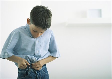 Boy fastening belt Stock Photo - Premium Royalty-Free, Code: 695-05777629