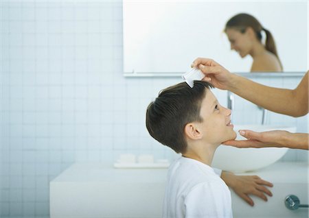 family bathroom mirror - Woman combing boy's hair Stock Photo - Premium Royalty-Free, Code: 695-05777648