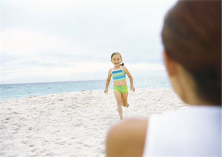 Girl running towards mother on beach Stock Photo - Premium Royalty-Free, Code: 695-05777906