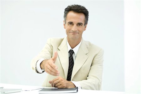 Businessman offering his hand to camera, smiling Stock Photo - Premium Royalty-Free, Code: 695-05779343