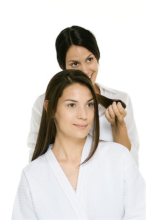 Hair stylist holding strands of a woman's hair, woman looking away and smiling Stock Photo - Premium Royalty-Free, Code: 695-05779439