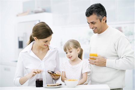 spreading (applying food) - Parents and young daughter preparing breakfast in kitchen Stock Photo - Premium Royalty-Free, Code: 695-05779513