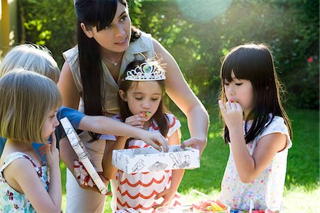 Mother helping daughter open gift at birthday party Stock Photo - Premium Royalty-Free, Code: 695-05779999