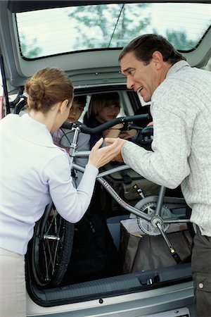 Parents struggling to pack car in preparation for road trip Stock Photo - Premium Royalty-Free, Code: 695-05770094