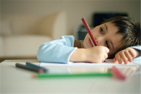 sleepy - Little boy pausing while drawing, resting head on arm Stock Photo - Premium Royalty-Free, Code: 695-05770151