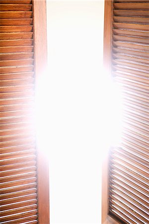 shutters - Wooden shutters partially opened to bright sunlight Stock Photo - Premium Royalty-Free, Code: 695-05770469