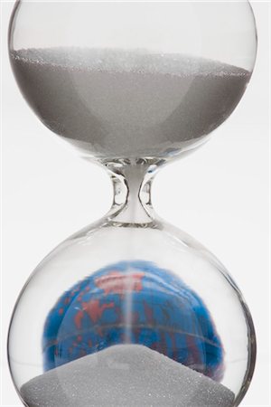 Hourglass, globe in background Stock Photo - Premium Royalty-Free, Code: 695-05770885