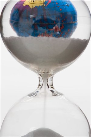 Hourglass, globe in background Stock Photo - Premium Royalty-Free, Code: 695-05770883