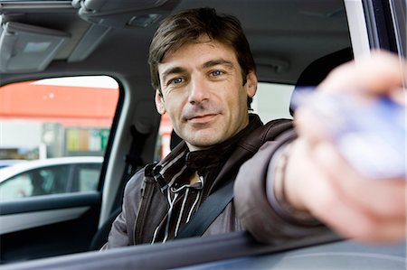 drive-thru - Mid-adult man in drive-thru handing credit card to check-out window clerk Stock Photo - Premium Royalty-Free, Code: 695-05770985