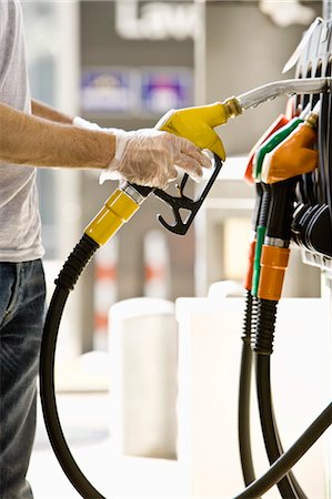 petrol station - Man at gas pump preparing to refuel vehicle Stock Photo - Premium Royalty-Free, Code: 695-05771024