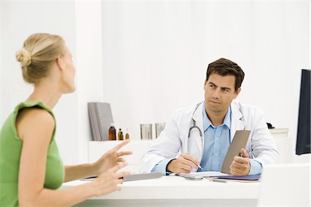 doctor office desk - Female patient speaking with doctor Stock Photo - Premium Royalty-Free, Code: 695-05771266