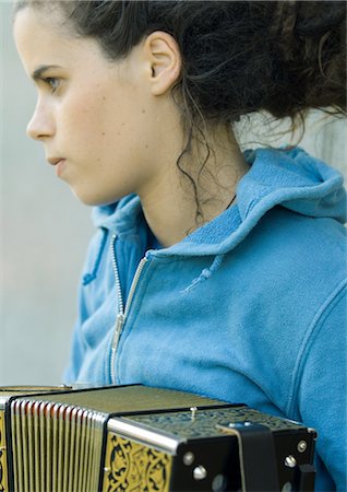 picture of the blue playing a instruments - Young woman playing accordian Stock Photo - Premium Royalty-Free, Code: 695-05772632