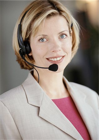 switchboard operator - Woman wearing headset, smiling at camera, portrait Stock Photo - Premium Royalty-Free, Code: 695-05772979