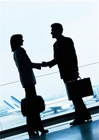 shadow plane - Businessman and businesswoman shaking hands in airport, silhouette. Stock Photo - Premium Royalty-Free, Code: 695-05773246