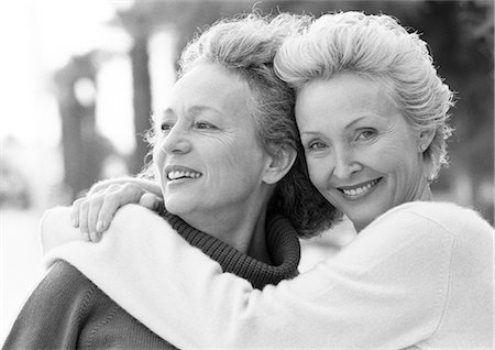 simsearch:400-06204561,k - Two mature women smiling, one with arms around the other's shoulders,  portrait, B&W Stock Photo - Premium Royalty-Free, Code: 695-05773446
