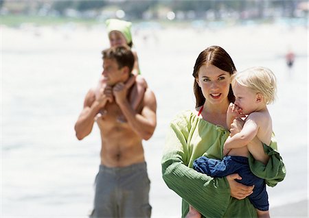 dad carrying teen son - Man and woman carrying children on the beach. Stock Photo - Premium Royalty-Free, Code: 695-05773942