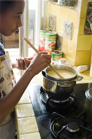 Girl stirring pot on stove Stock Photo - Premium Royalty-Free, Code: 695-05780089