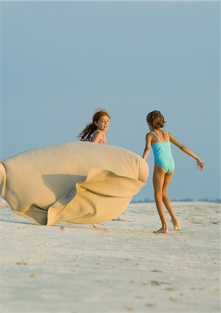 simsearch:633-01714467,k - Two girls running on beach, holding blanket out in wind Stock Photo - Premium Royalty-Free, Code: 695-03374049