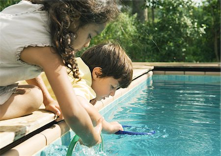 simsearch:695-03374346,k - Two children leaning over edge of swimming pool Stock Photo - Premium Royalty-Free, Code: 695-03374360