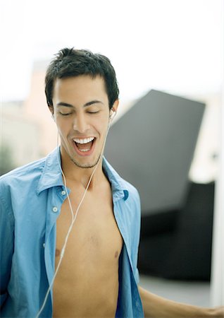 stalemate - Young man listening to earphones, singing Foto de stock - Sin royalties Premium, Código: 695-03374446